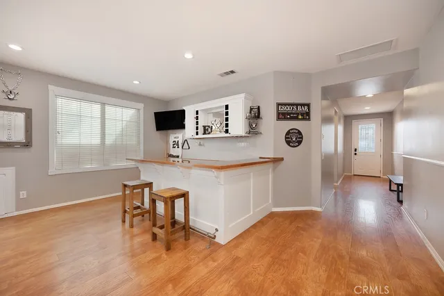 a living room with stainless steel appliances kitchen island hardwood floor and a kitchen view