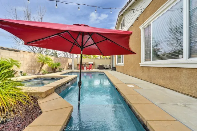 a view of a patio with a table and chairs under an umbrella