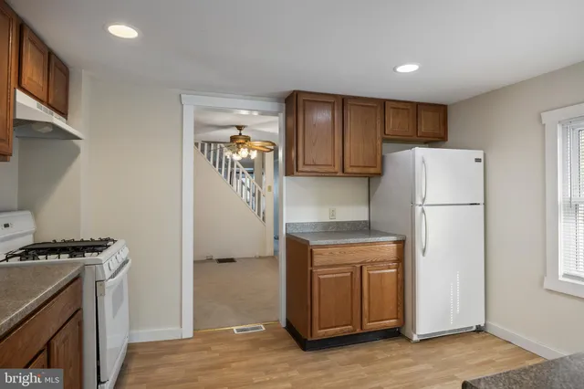 a bathroom with a toilet a sink a vanity and a window