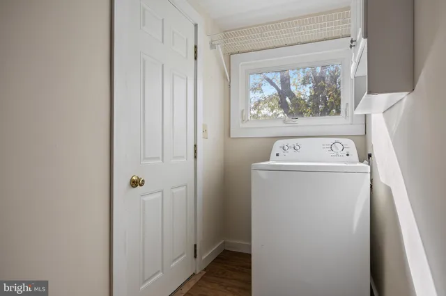 a view of an empty room with window and closet area