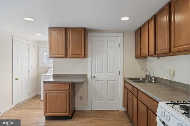 a kitchen with granite countertop wooden cabinets and a stove top oven