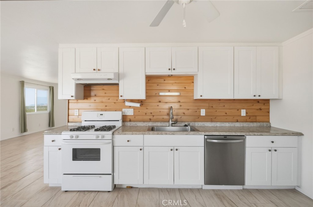 66270 Brant Crossing Road Joshua Tree, CA 92252 - Photo 11 of 46 a kitchen with white cabinets stainless steel appliances and sink