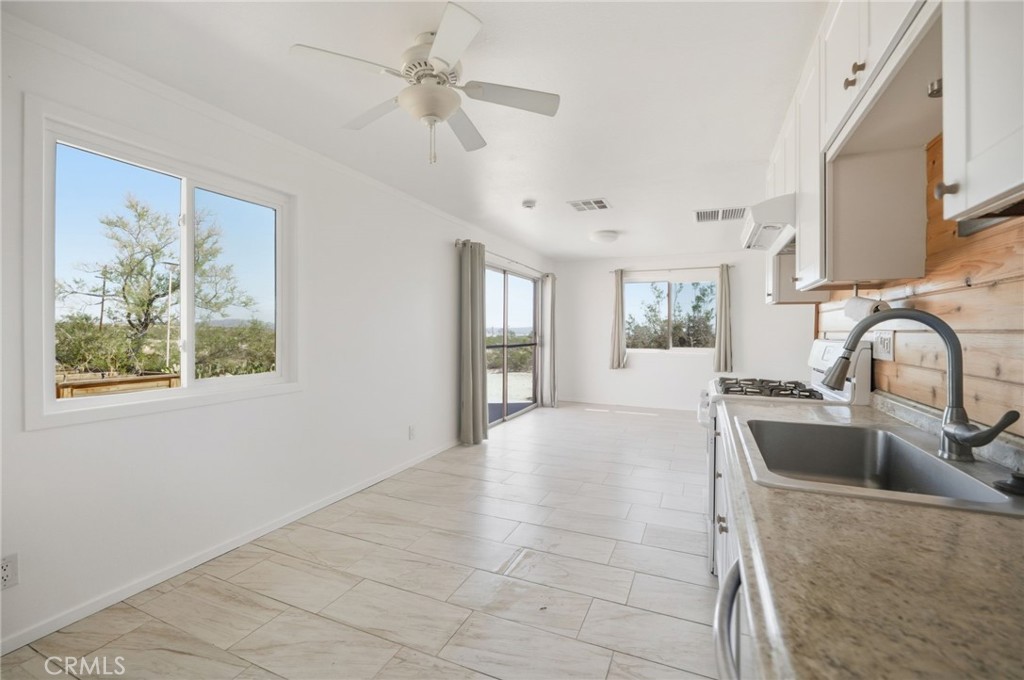 66270 Brant Crossing Road Joshua Tree, CA 92252 - Photo 26 of 46 a large kitchen with stainless steel appliances granite countertop a sink a stove cabinets and a dining table