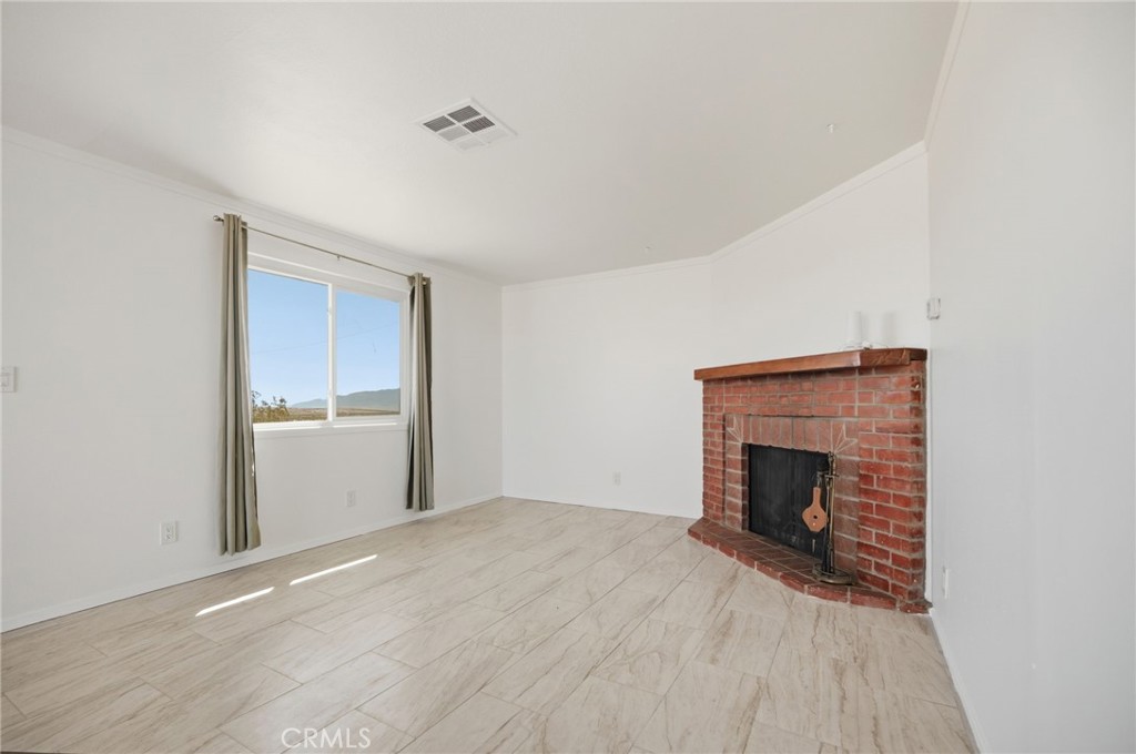 66270 Brant Crossing Road Joshua Tree, CA 92252 - Photo 27 of 46 a view of empty room with a fireplace and wooden floor