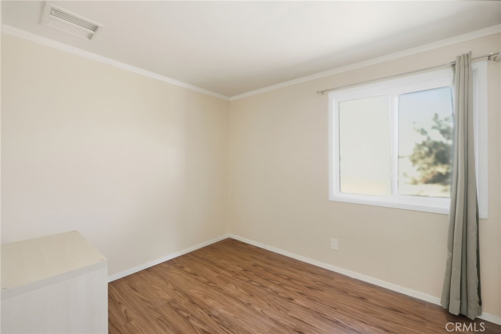 66270 Brant Crossing Road Joshua Tree, CA 92252 - Photo 30 of 46 an empty room with wooden floor and windows