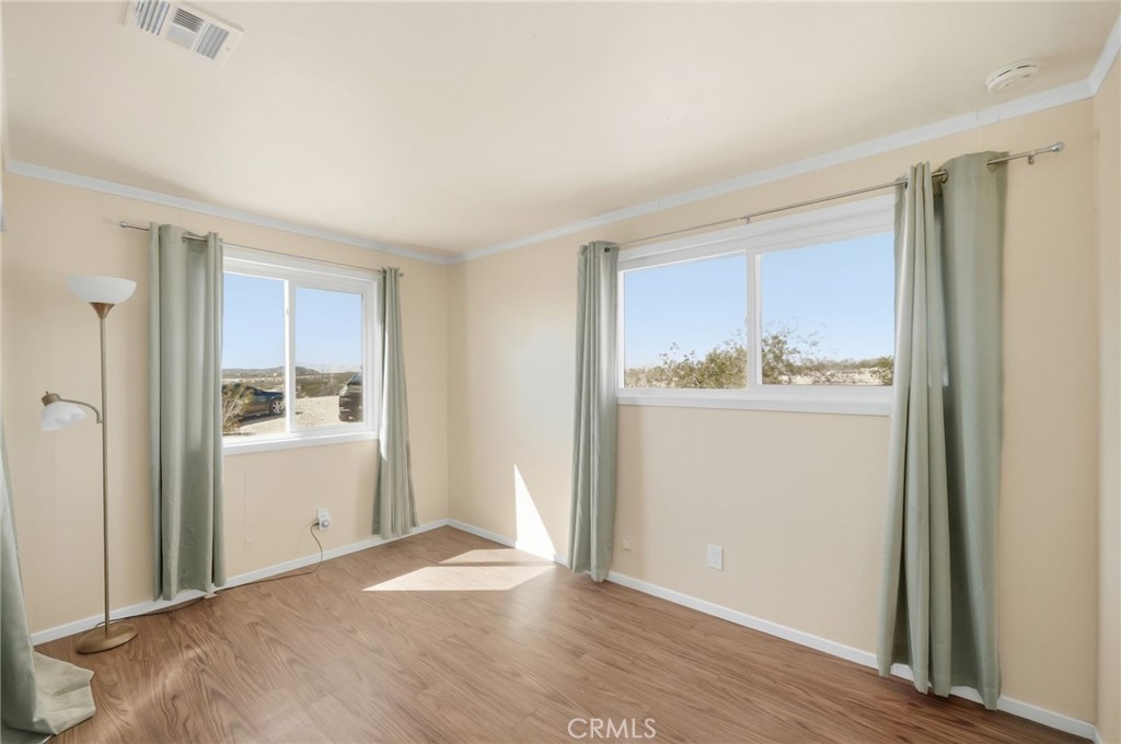 66270 Brant Crossing Road Joshua Tree, CA 92252 - Photo 32 of 46 a room view with wooden floor and window