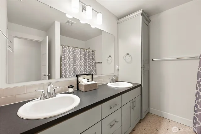 a bathroom with a double vanity sink and mirror