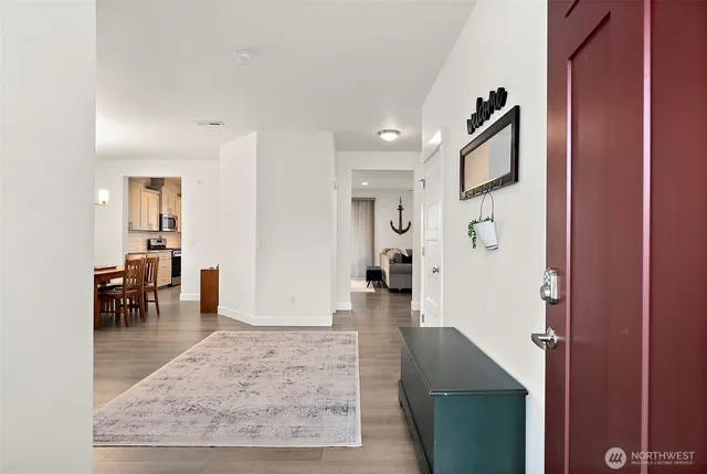 a view of a hallway with wooden floor and furniture