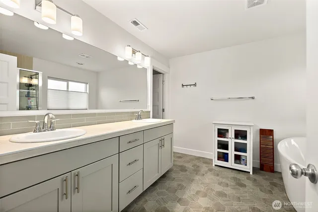 a spacious bathroom with double vanity a double vanity sink a large mirror and a shower