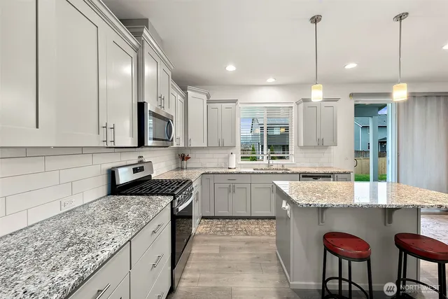 a kitchen with granite countertop kitchen island cabinets and refrigerator