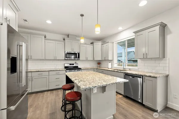 a kitchen with stainless steel appliances granite countertop a sink stove and refrigerator