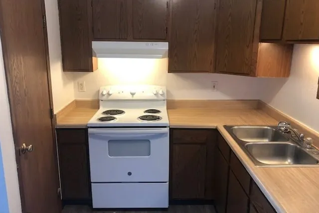 a kitchen with a sink a stove and cabinets