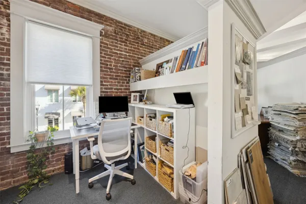 a view of a workspace with furniture and a window