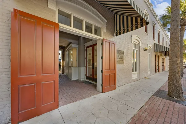 a view of a hallway with wooden floor and windows