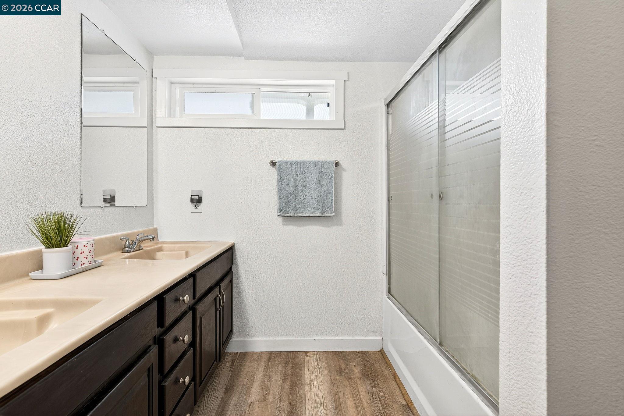 2312 Granada Court Pinole, CA 94564 - Photo 27 of 60 a bathroom with a granite countertop sink a mirror and shower