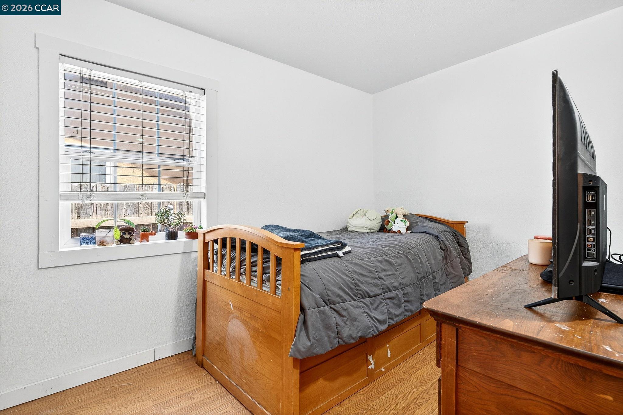 2312 Granada Court Pinole, CA 94564 - Photo 33 of 60 a bedroom with a bed and a flat tv screen on the dresser