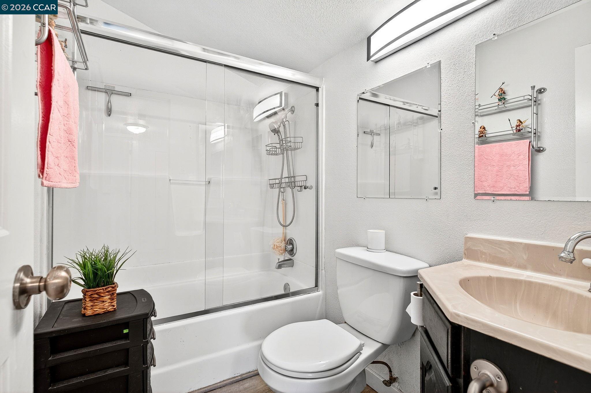 2312 Granada Court Pinole, CA 94564 - Photo 35 of 60 a bathroom with a granite countertop sink toilet a large mirror and shower