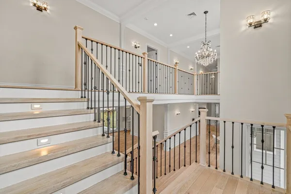 a view of staircase with railing and pendant lights