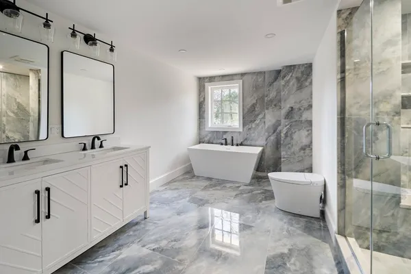 a bathroom with a double vanity sink mirror and bathtub