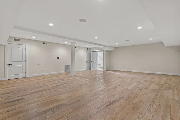 a view of an empty room with wooden floor