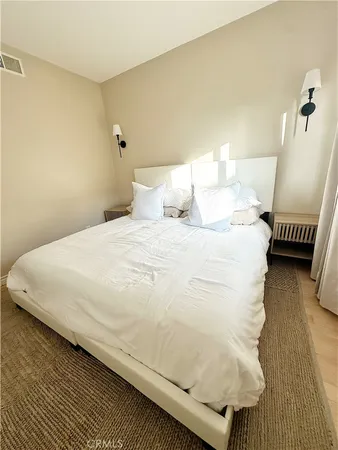 a large bed sitting in a bedroom next to a lamp