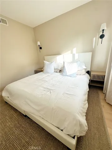 a large bed sitting in a bedroom next to a lamp