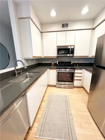 a kitchen with stainless steel appliances granite countertop a sink and a stove