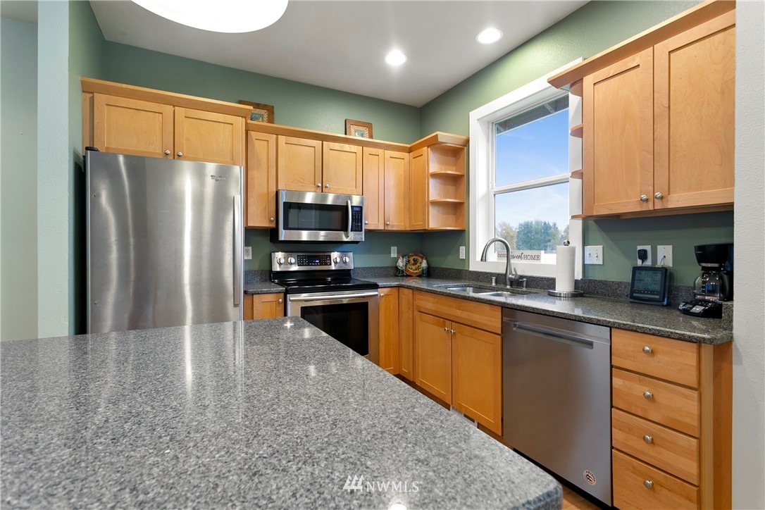 106 Ridgeview Street Sumas, WA 98295 - Photo 21 of 31 a kitchen with stainless steel appliances granite countertop a refrigerator a sink dishwasher a stove top oven a refrigerator and cabinets