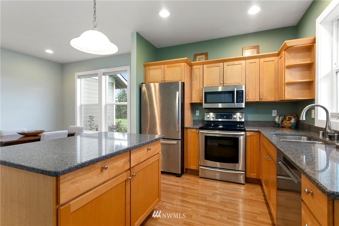 106 Ridgeview Street Sumas, WA 98295 - Photo 22 of 31 a kitchen with stainless steel appliances granite countertop a sink a stove a refrigerator cabinets and a large window