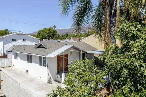 a aerial view of a house with a yard and potted plants