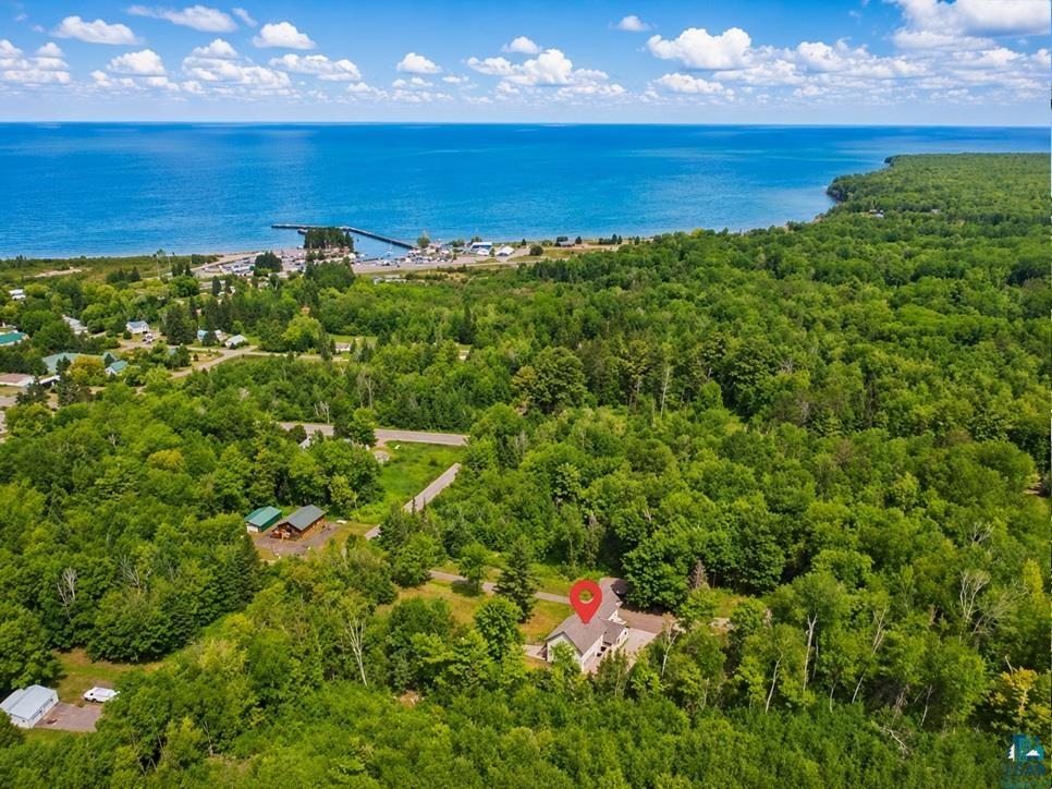 88440 Huron Street Cornucopia, WI 54827 - Photo 2 of 44 Aerial perspective showcasing a single-family residence surrounded by dense tree cover and located near Lake Superior.