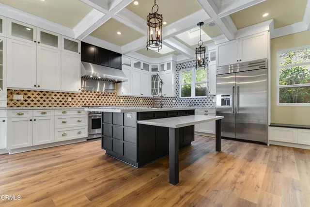 a kitchen with stainless steel appliances kitchen island granite countertop a stove a sink and a refrigerator