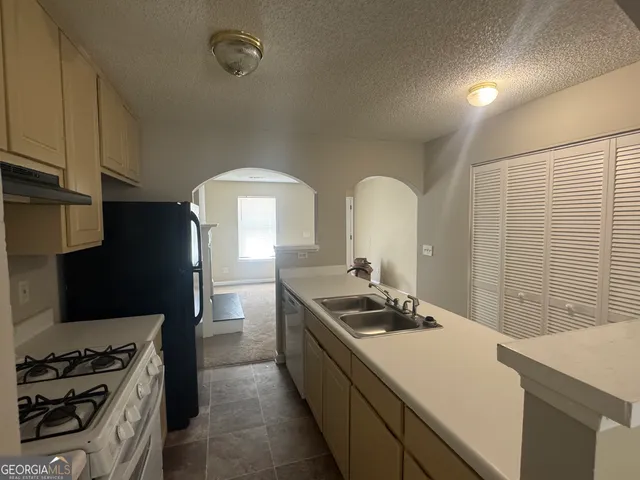 a kitchen with stainless steel appliances a sink a stove and a refrigerator