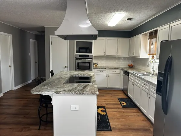 a kitchen with a stove a sink and a refrigerator