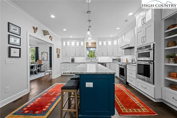 a kitchen with stainless steel appliances granite countertop a stove top oven a sink dishwasher and a refrigerator