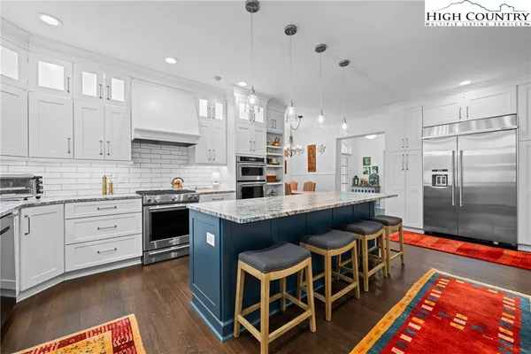 a kitchen with stainless steel appliances granite countertop a sink stove and wooden floor