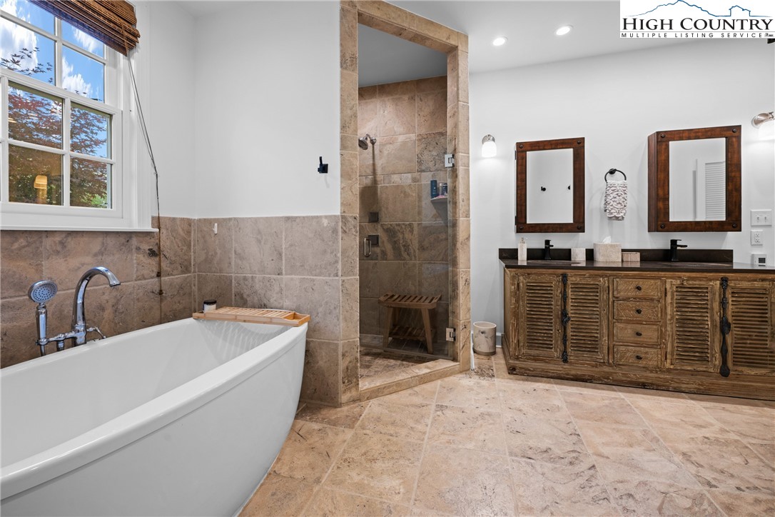 1920 Deck Hill Road Blowing Rock, NC 28605 - Photo 25 of 50 a bathroom with a tub sink double vanity granite tub shower and mirror