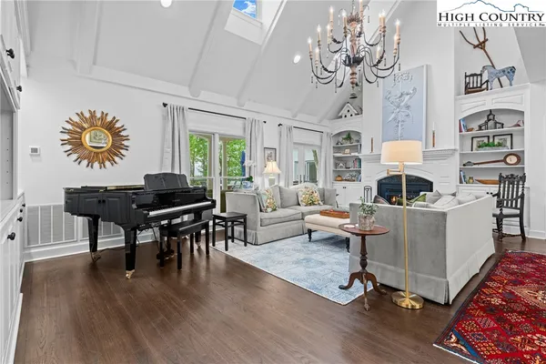 a living room with furniture a chandelier and a flat screen tv