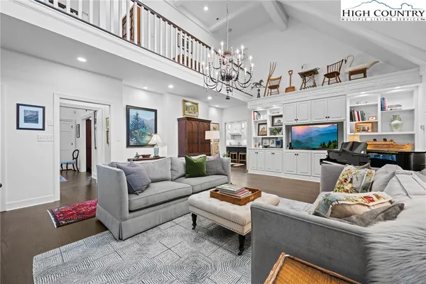 a living room with furniture a chandelier and a dining table