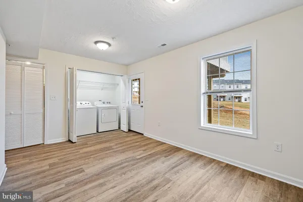 a view of an empty room with closet and a window