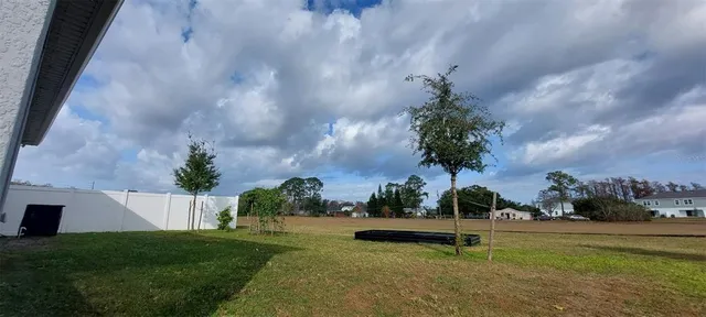 a backyard of a house with barbeque oven table and chairs