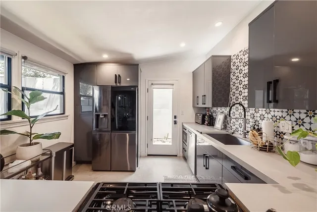 a kitchen with stainless steel appliances a stove a sink and a refrigerator