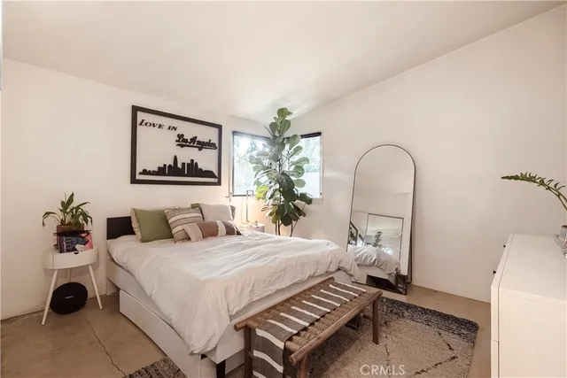 a bedroom with a bed and a potted plant