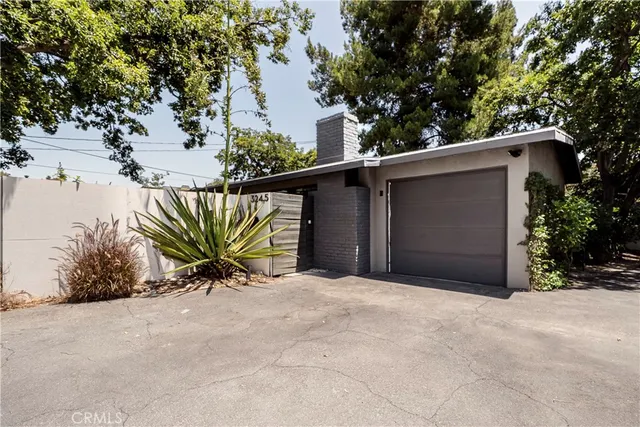 a view of a house with a yard and potted plants