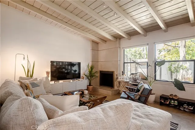 a living room with furniture a flat screen tv and a floor to ceiling window