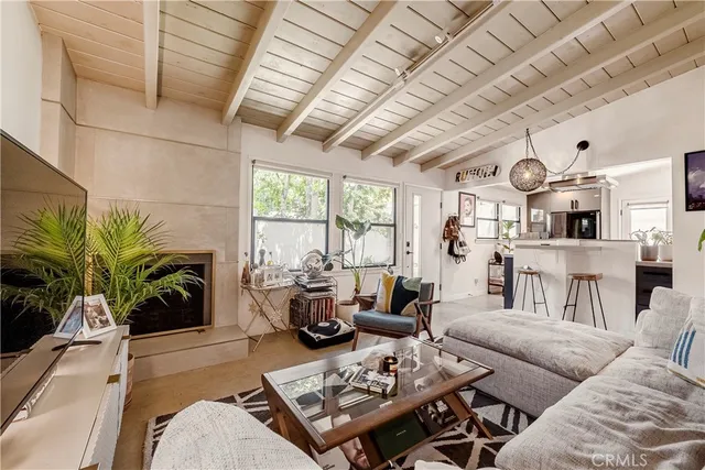 a living room with furniture kitchen view and a large window