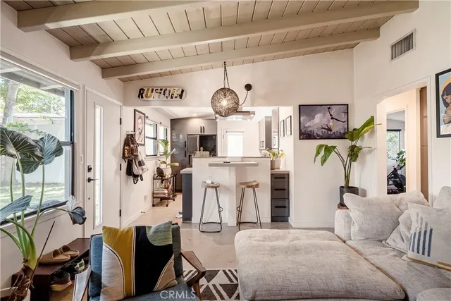 a living room with furniture a chandelier and a dining table