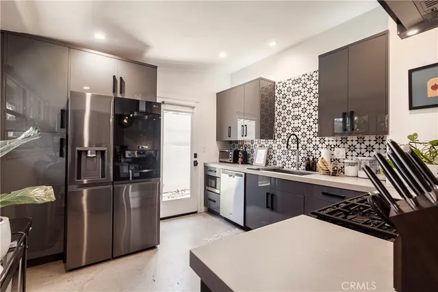 a kitchen with stainless steel appliances a refrigerator sink and stove