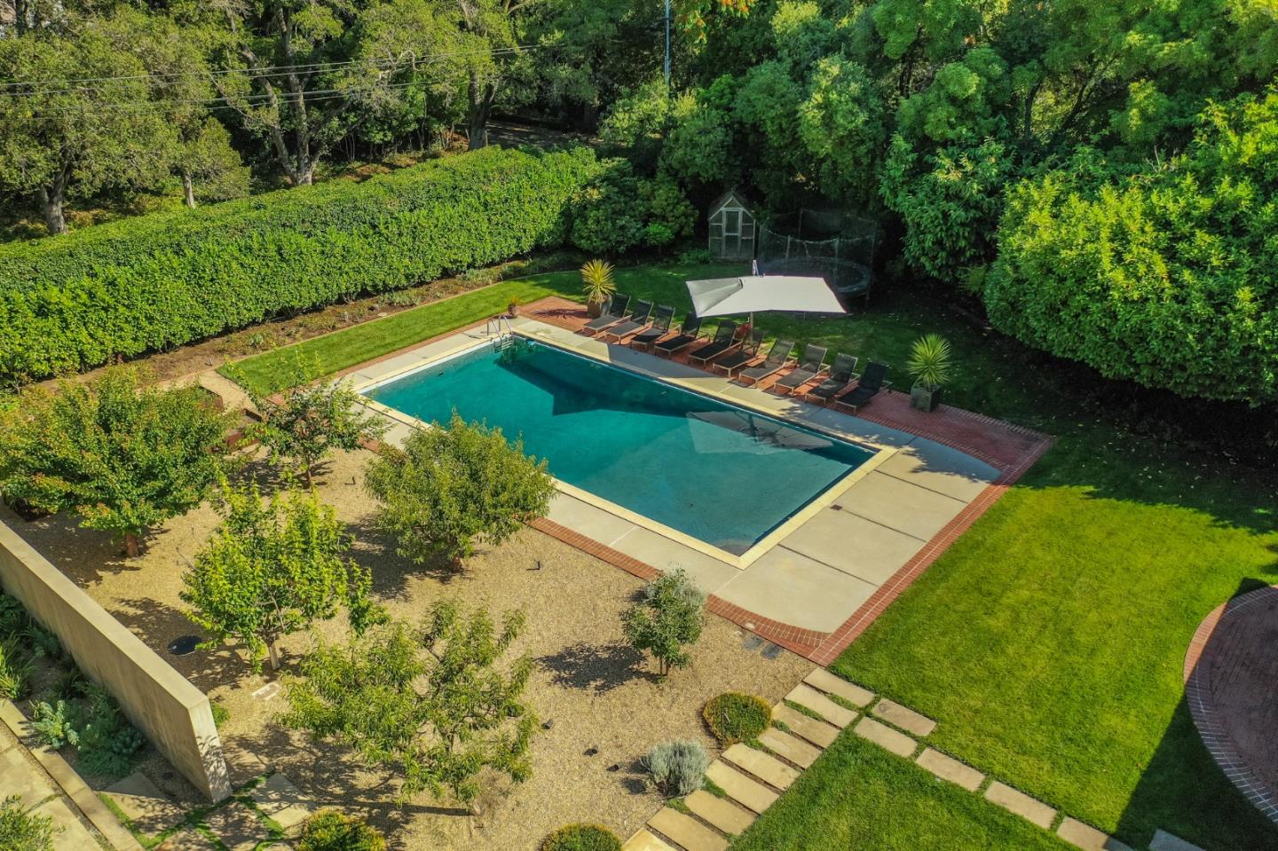 190 Bridge Road Hillsborough, CA 94010 - Photo 11 of 14 a view of a backyard with lawn chairs under an umbrella