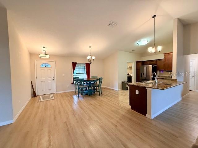1026 Southeast 65th Circle Ocala, FL 34472 - Photo 4 of 29 a kitchen with stainless steel appliances kitchen island granite countertop a stove a refrigerator a sink a dining table and chairs with wooden floor